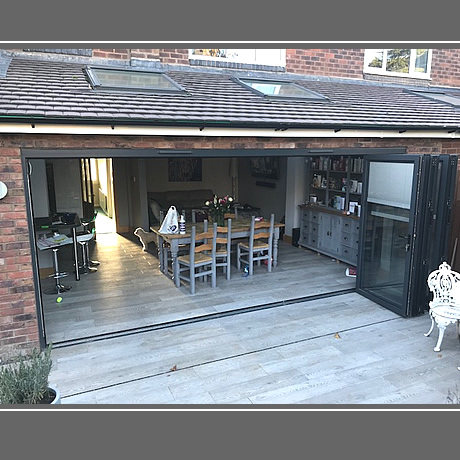 A 5 pane Smart Aluminium bi-folding door in anthracite grey finish with integral blinds installed in solihull, www.solihullwindows.co.uk