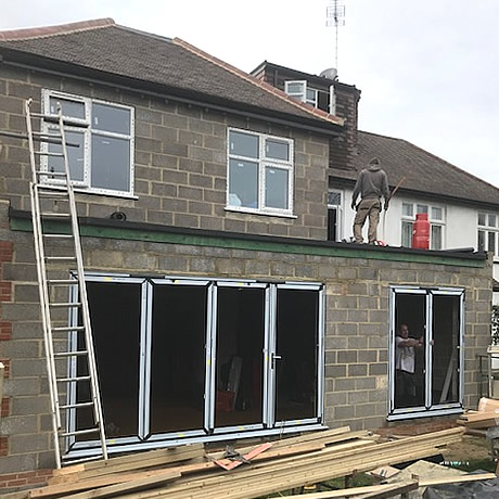 a 4 pane and 2 pane smarts aluminium bi-folding door being installed in North Wembley, London by Solihull WDC (www.solihullwindows.co.uk)